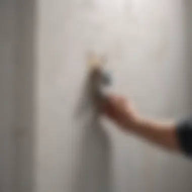 Person sealing a hole in the wall with caulk